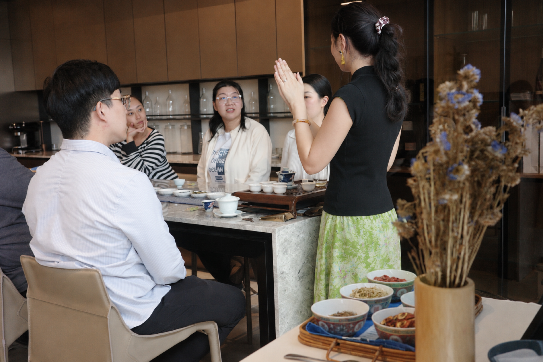 Hands arranging tea vessels