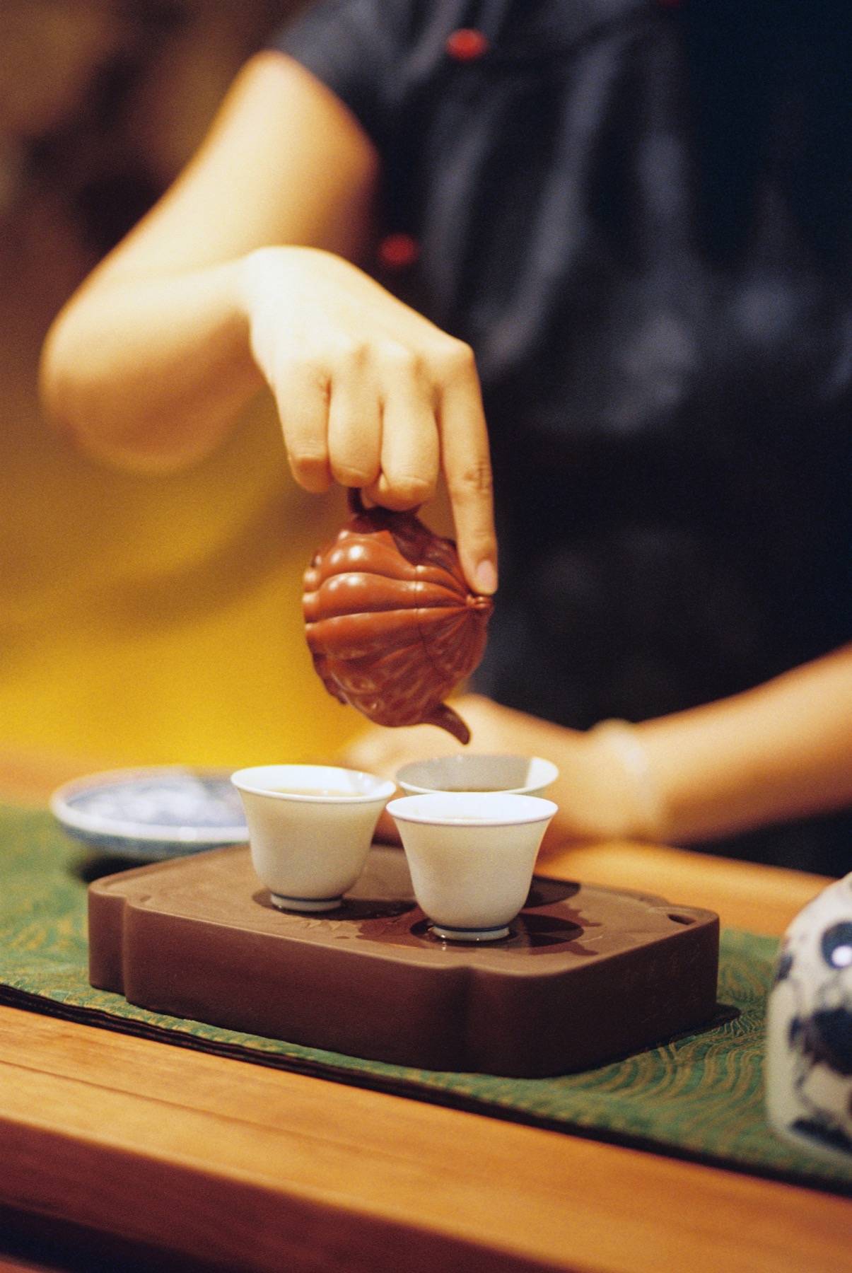 Pouring tea from a small clay teapot